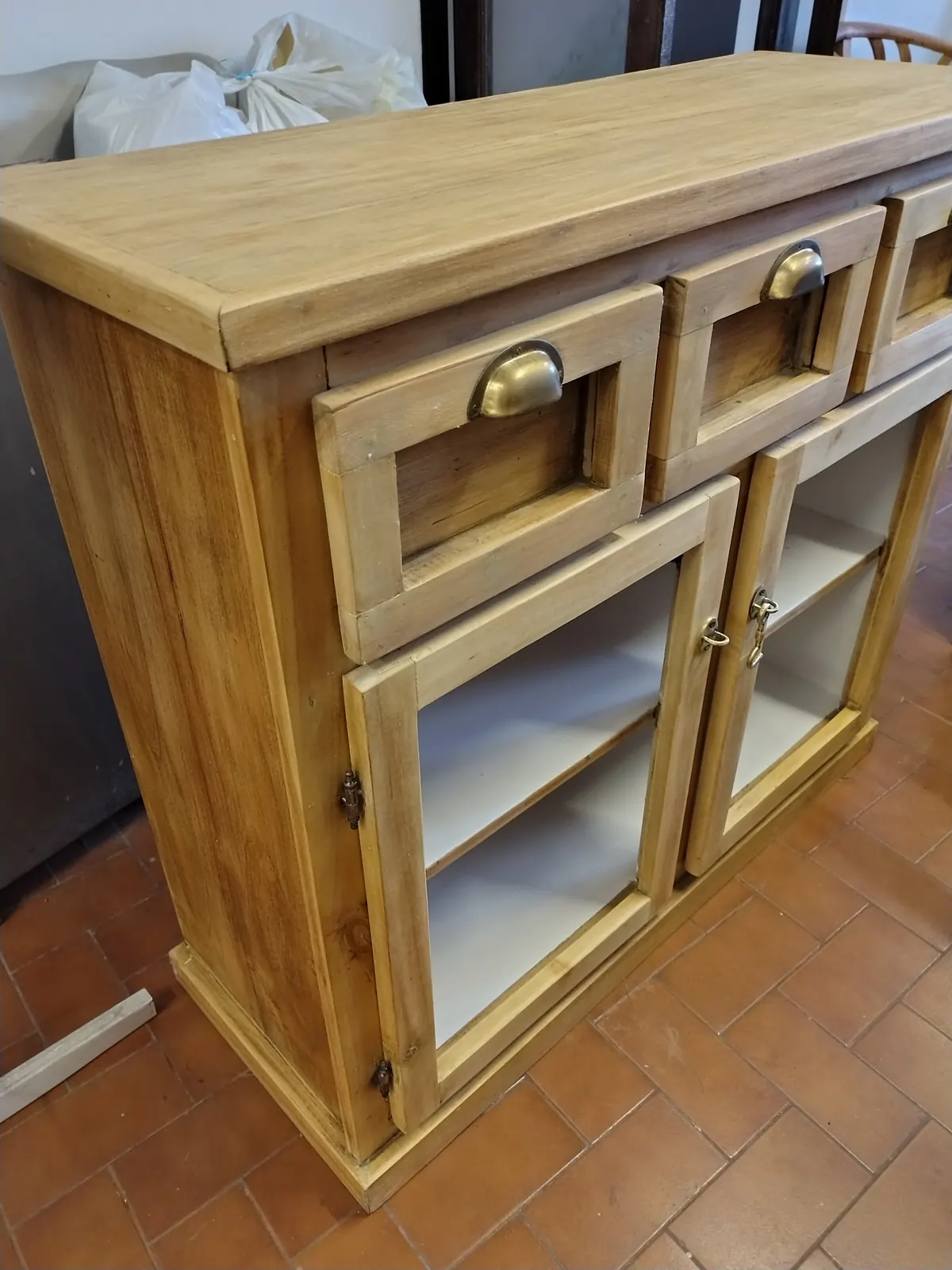 Cajonera restaurada, con terminación en madera clara.